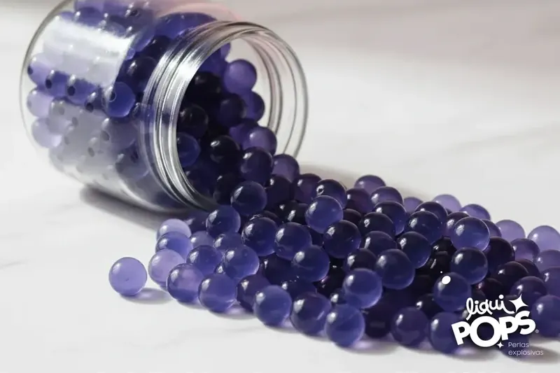 Popping boba LiquiPops sabor blueberry saliendo del tarro